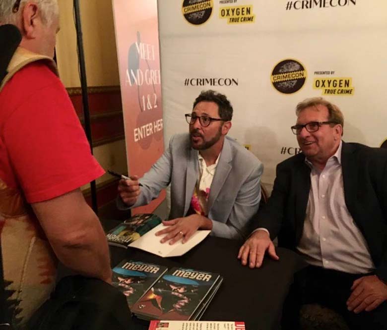 Meyer II and Jonathan Lang signing books at CrimeCon 2022